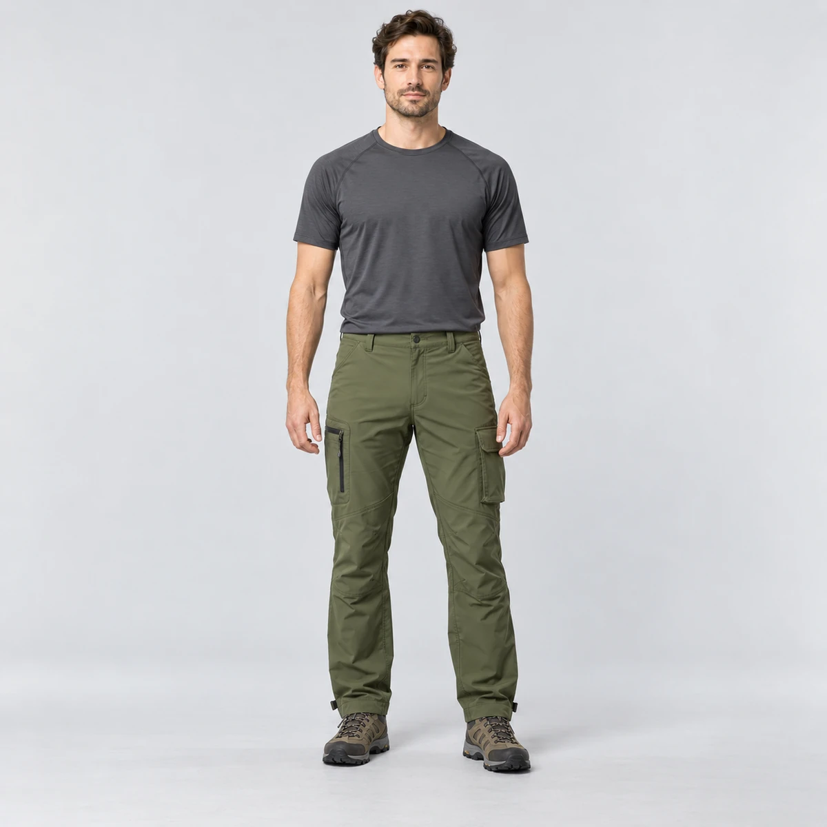 Man wearing a rain shell with cargo hiking pants on a white background
